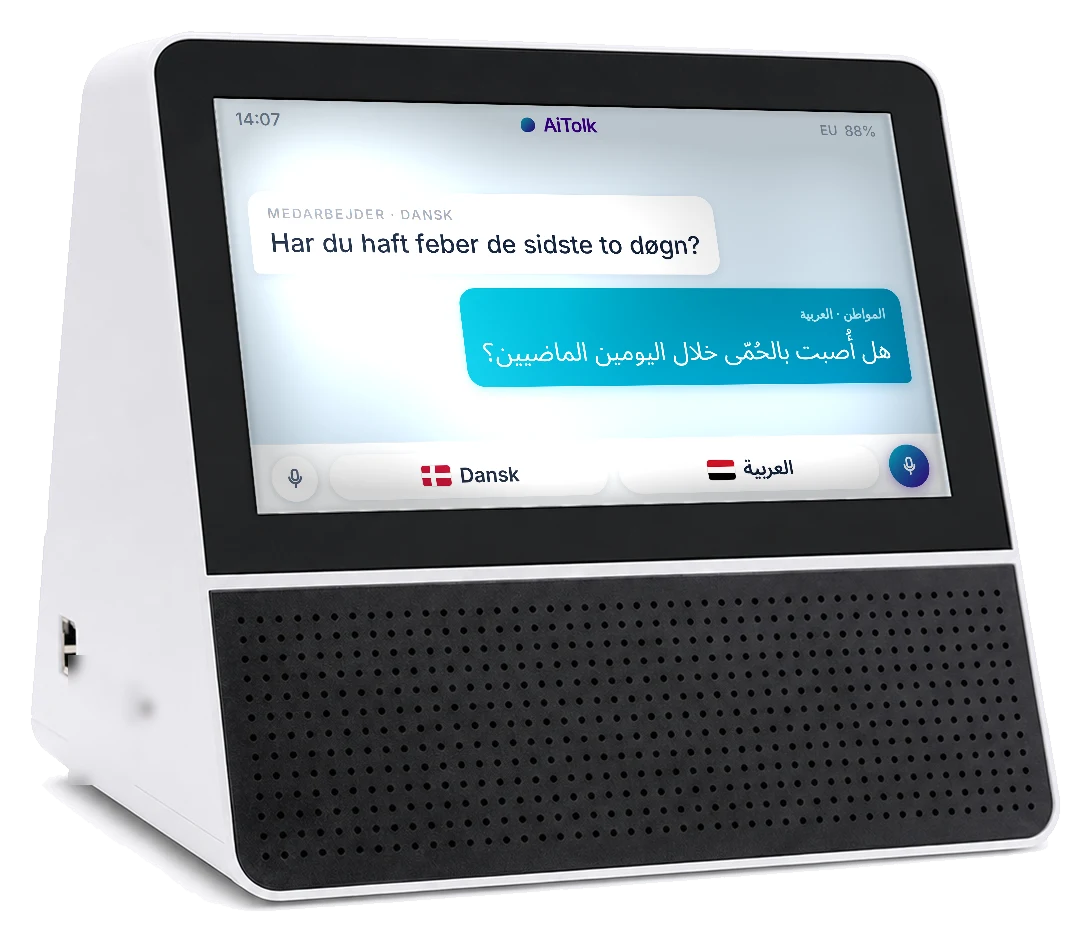 AiTolk-enheden set skråt forfra. På skærmen står et dansk spørgsmål og den arabiske oversættelse.